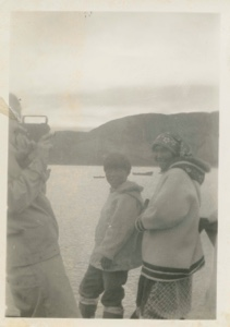 Image of Miriam MacMillan using movie camera; Eskimo [Inuit] boy and woman watching